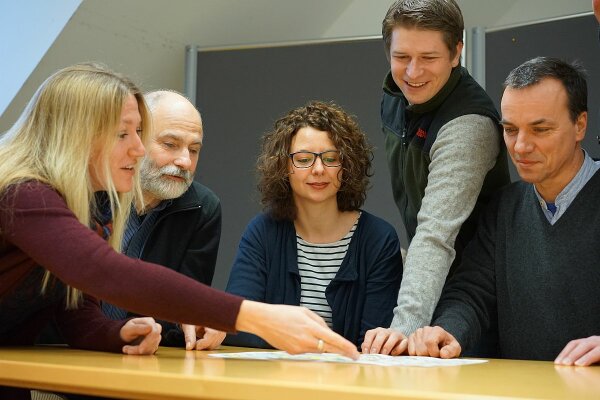 Mehrere Waldbesitzerinnen und Waldbesitzer an Tisch mit Forstbetriebskarte oder Flurstückkarte (Foto: Michael Friedel)